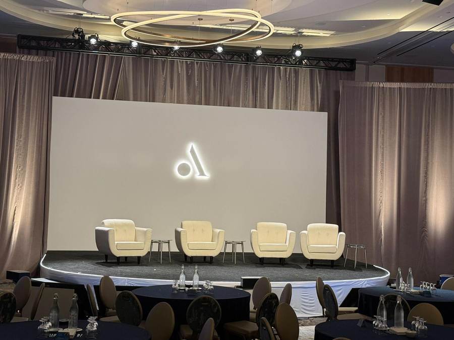 Executive panel stage with white LED surface and illuminated logo