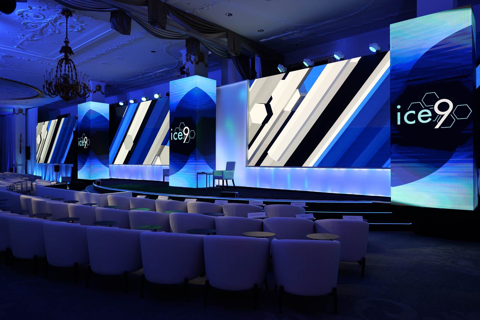 Hotel ballroom with LED pillars, a wide LED wall and lounge seating with place cards