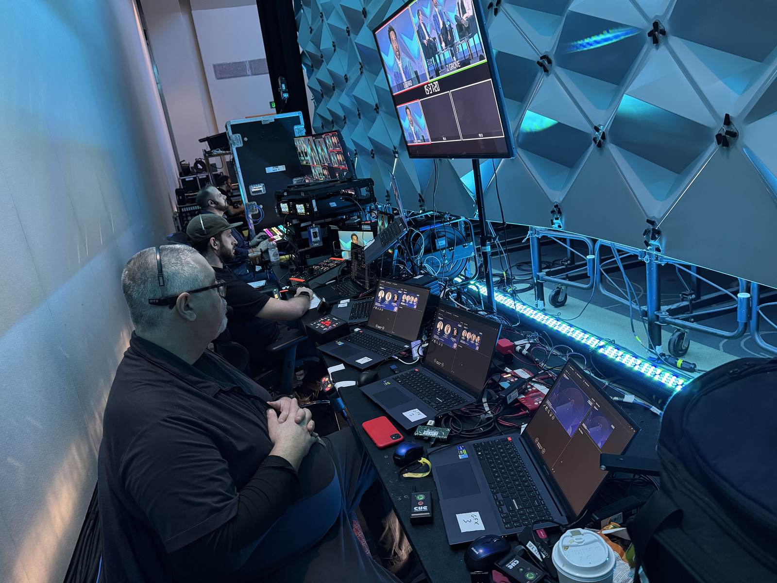 Show control position with multiview monitor, graphics laptops and crew on headsets